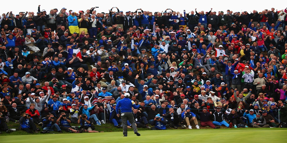 Crowd of people watching a golfer celebrate on the golf green
