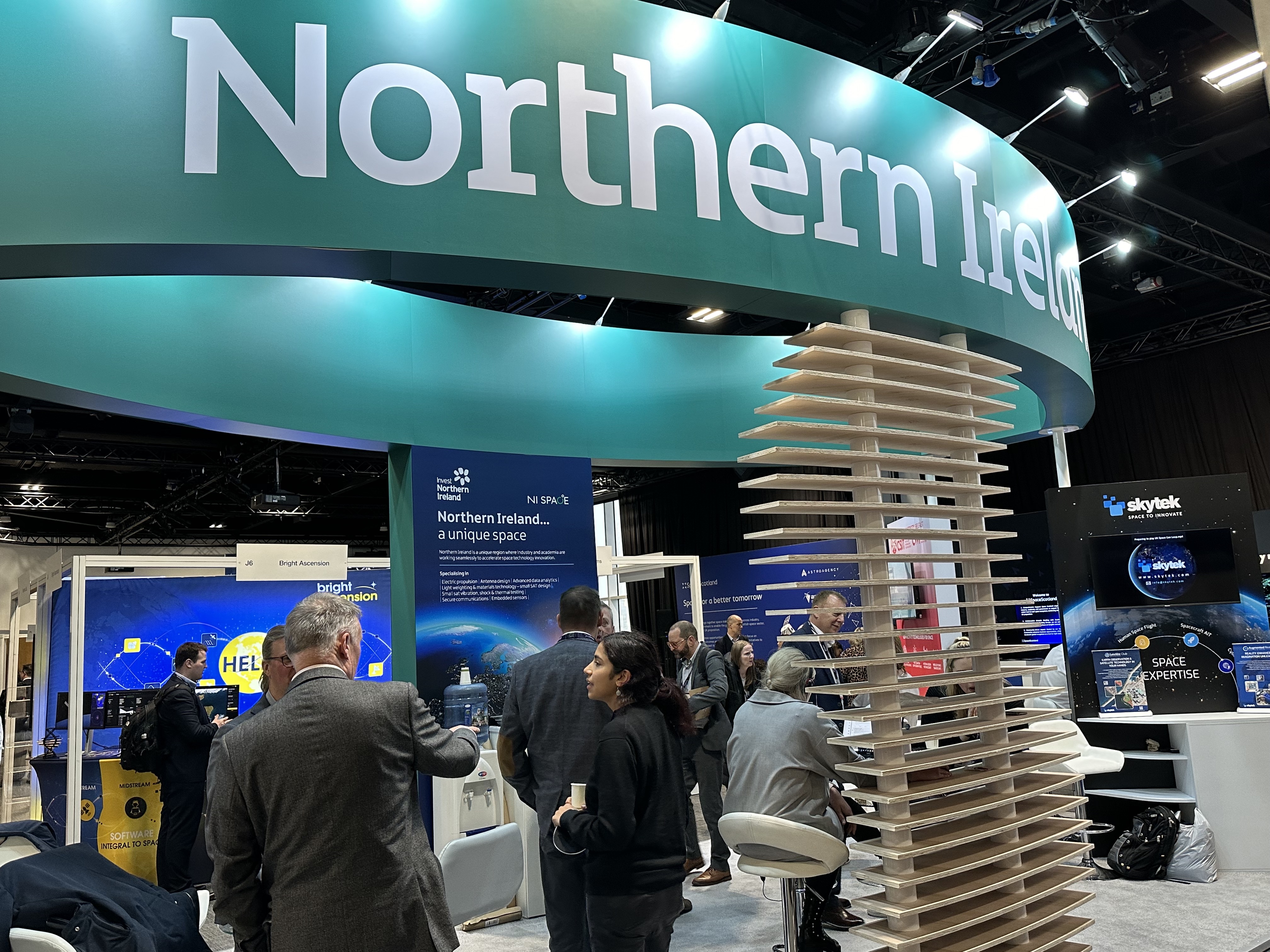 A stand at a conference, with people stood around chatting.